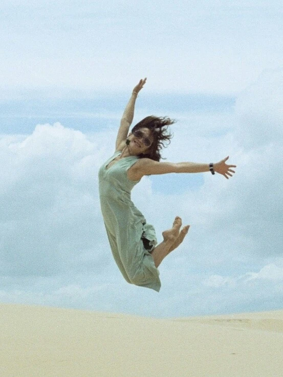 Frau springt in der Wüste in die Luft